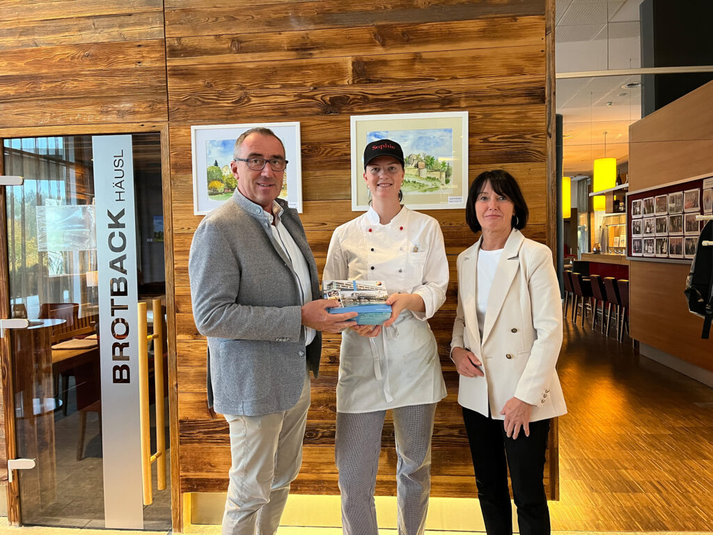 Geschenksübergabe der Geschäftsführung an einen Lehrling zur bestandenen Lehrabschlussprüfung.