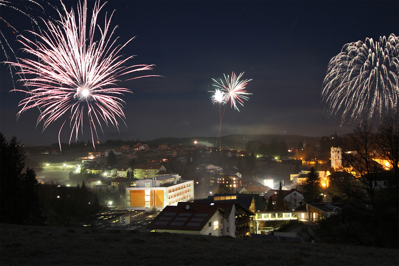 Man sieht Bad Zell bei Nacht und Feuerwerke am Himmel-