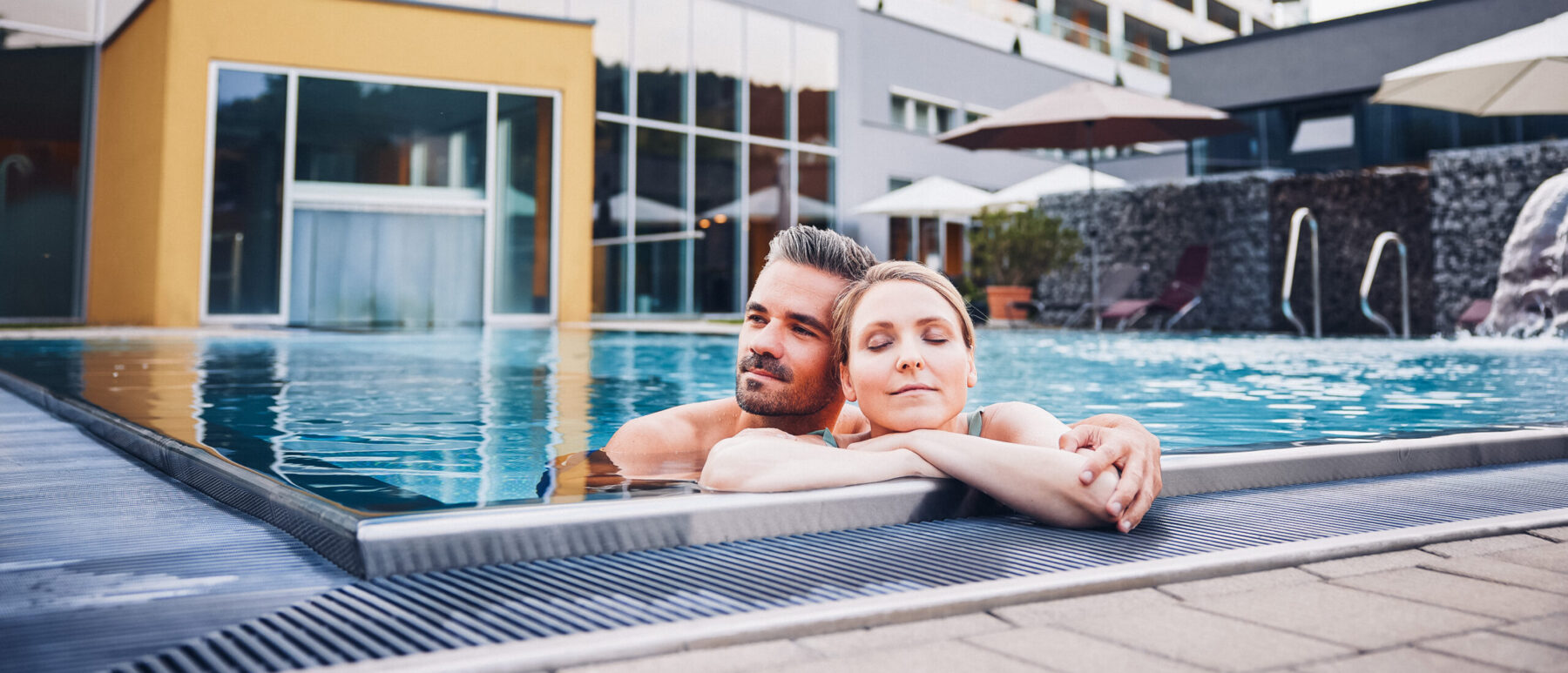 Paar entspannt am Poolrand