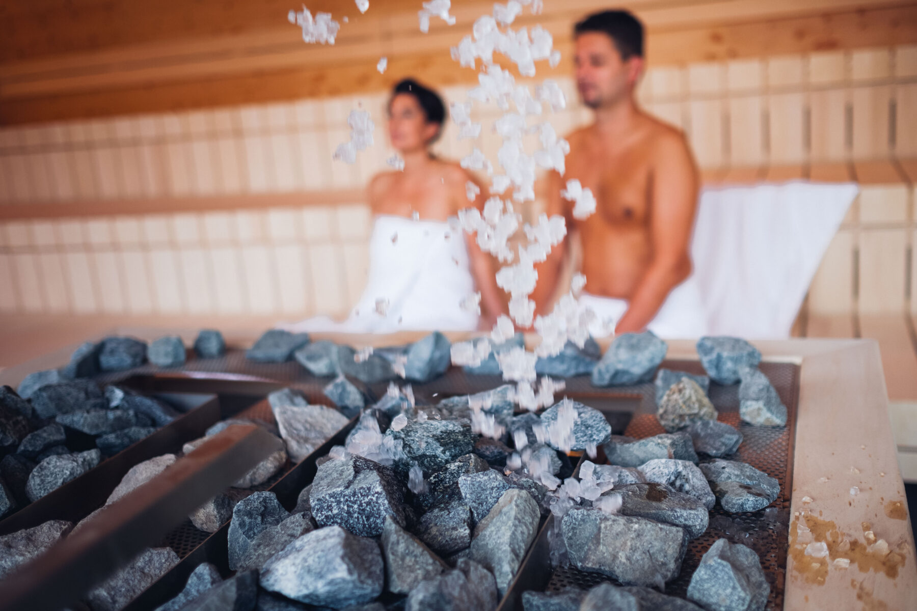 Paar sitzt in der Sauna bei laufendem Aufguss