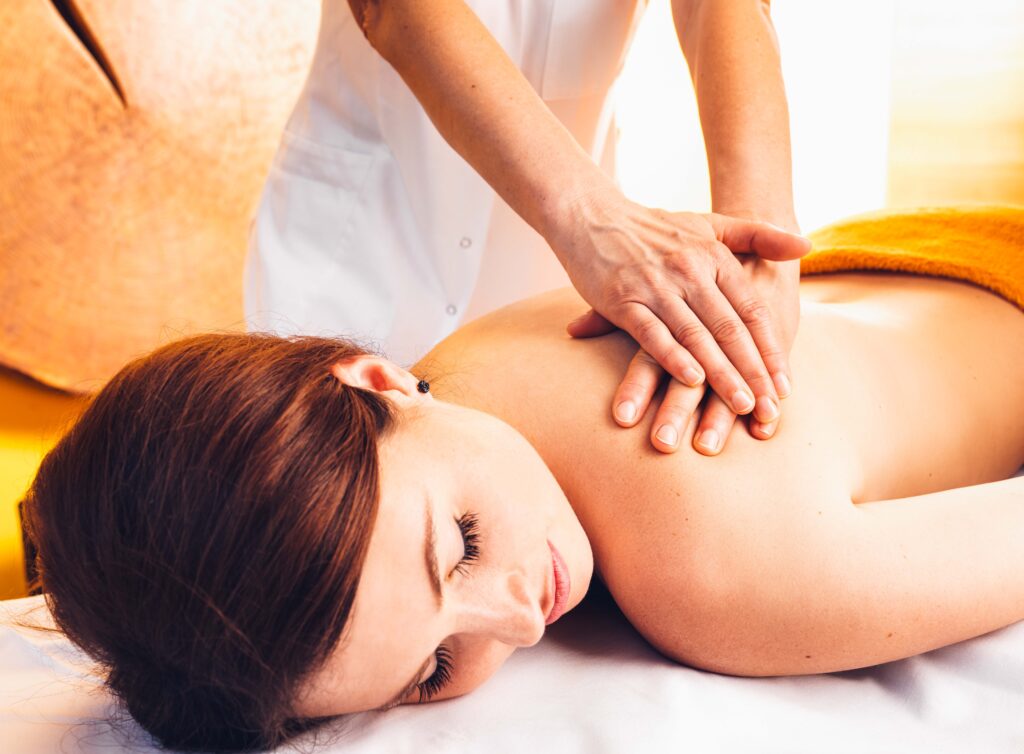 Eine Dame liegt auf der Massageliege und genießt ihre Massage.