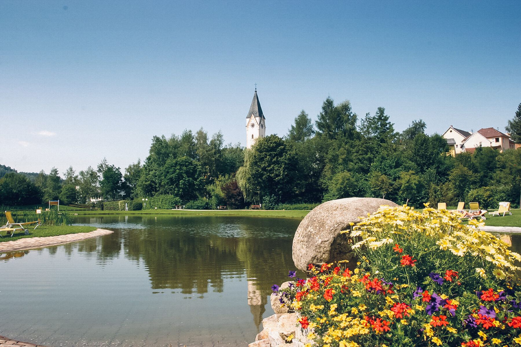 Man sieht den Badeteich in Bad Zell mit Blick auf die Kirche.
