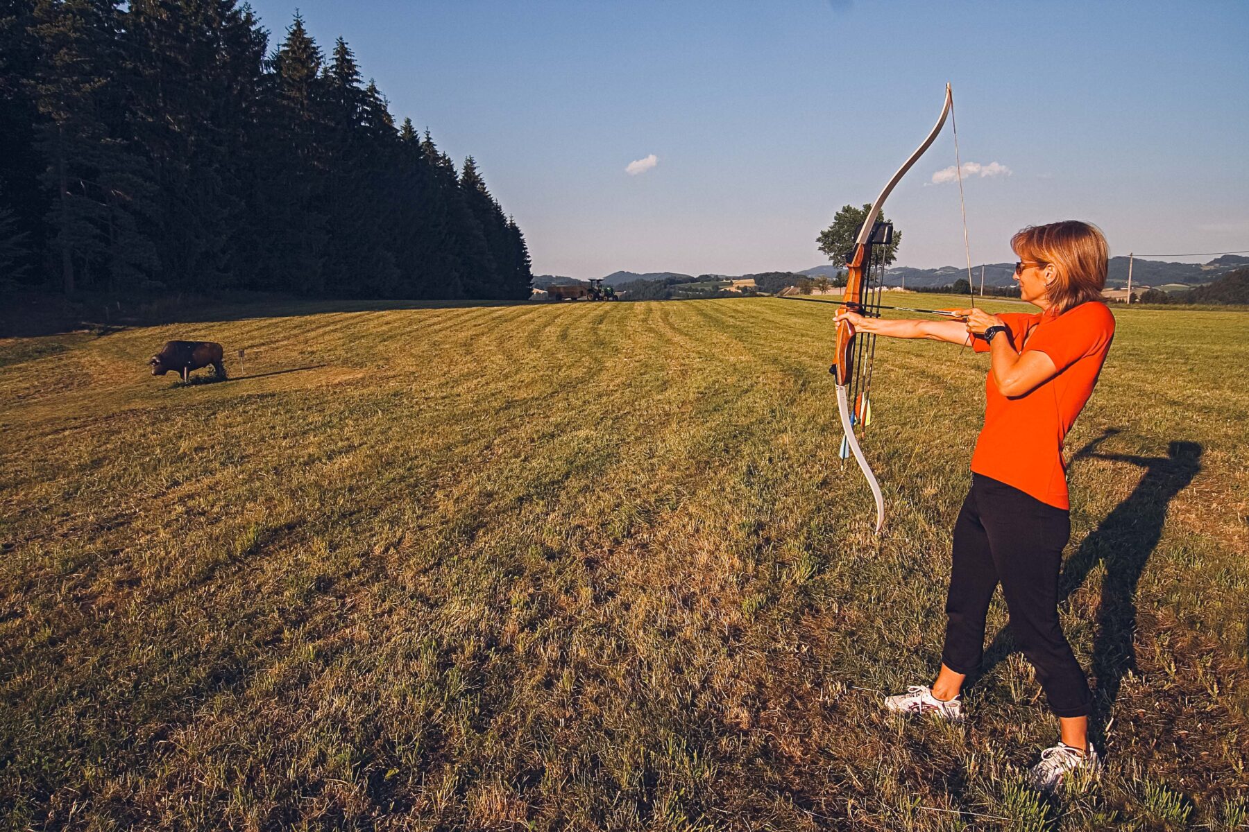Man sieht eine Frau beim Bogenschießen.