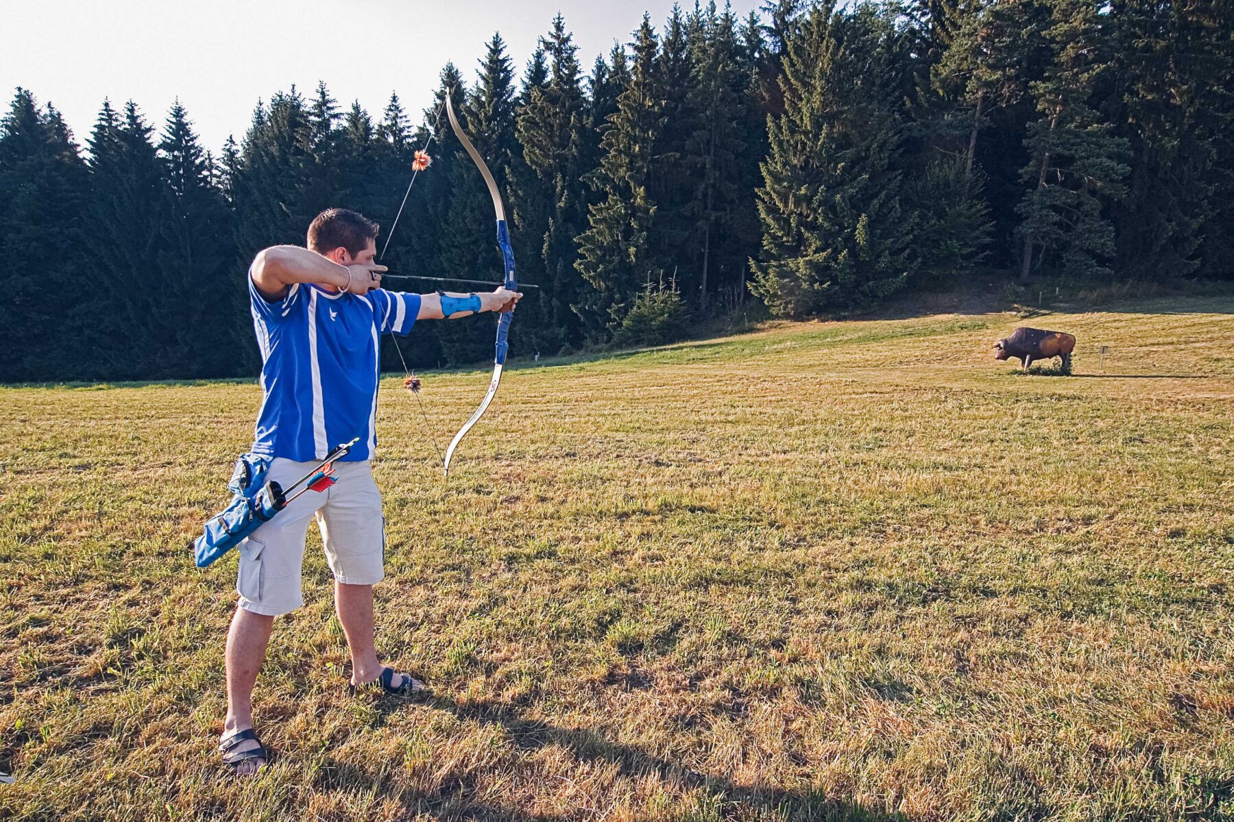Man sieht einen Mann beim Bogenschießen.