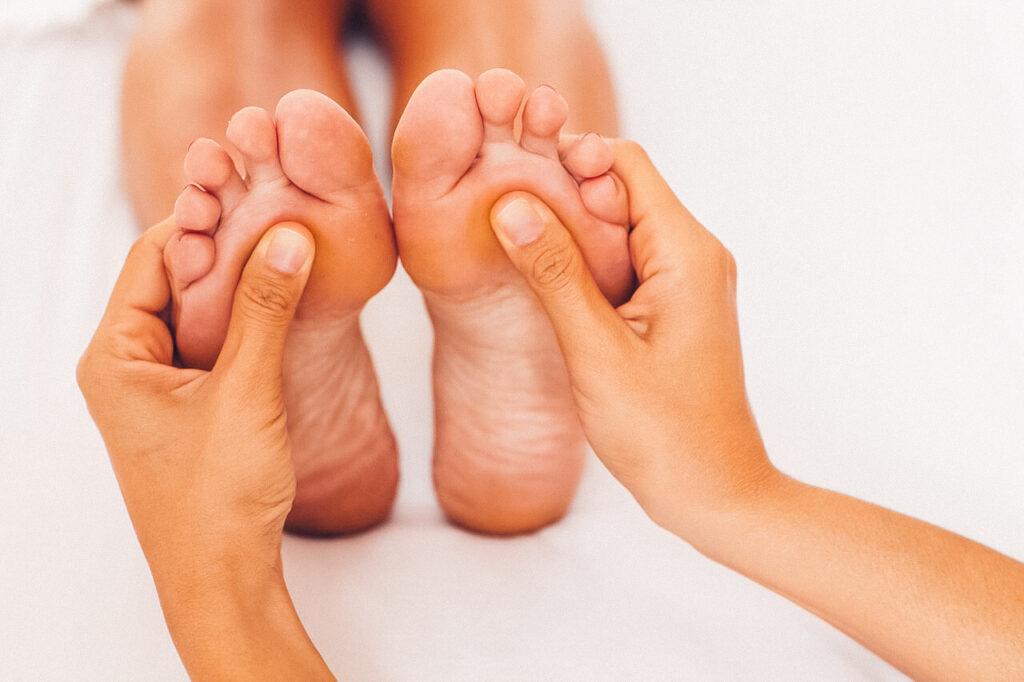 Jemand massiert die Fußsohlen einer anderen Person.