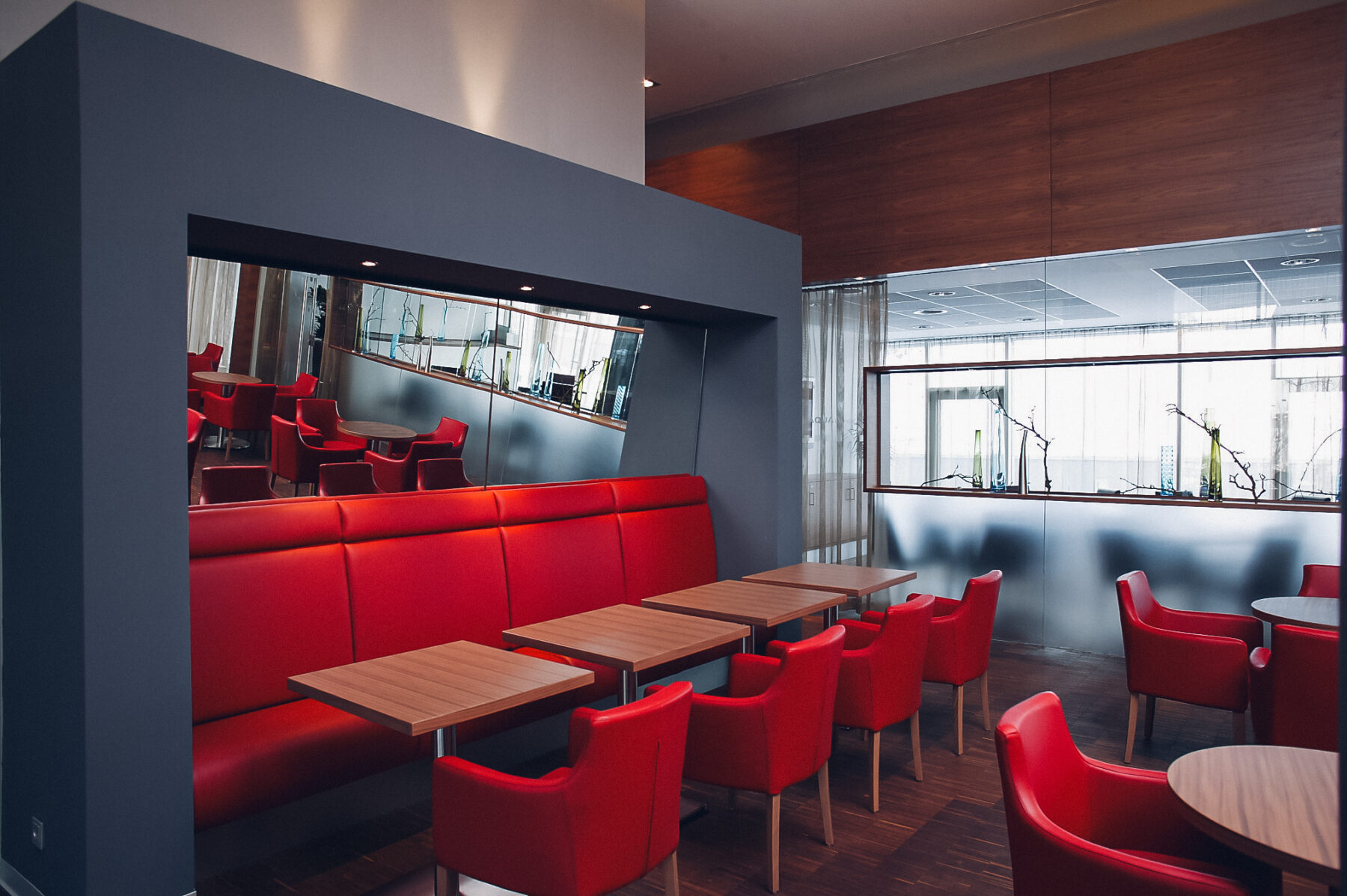 Sessel und Tische an der Hotelbar, die sich auch im Spiegel spiegeln