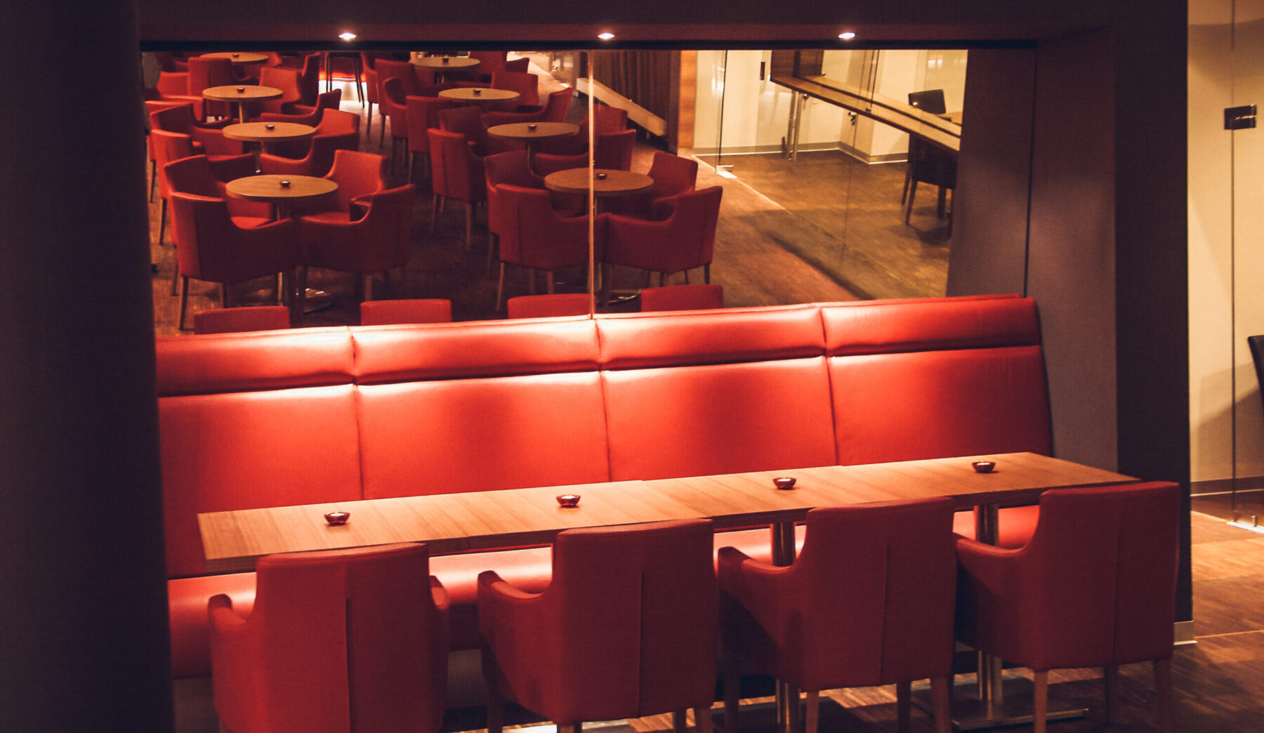 Sessel und Tische in der Hotelbar welche sich im Spiegel spiegeln