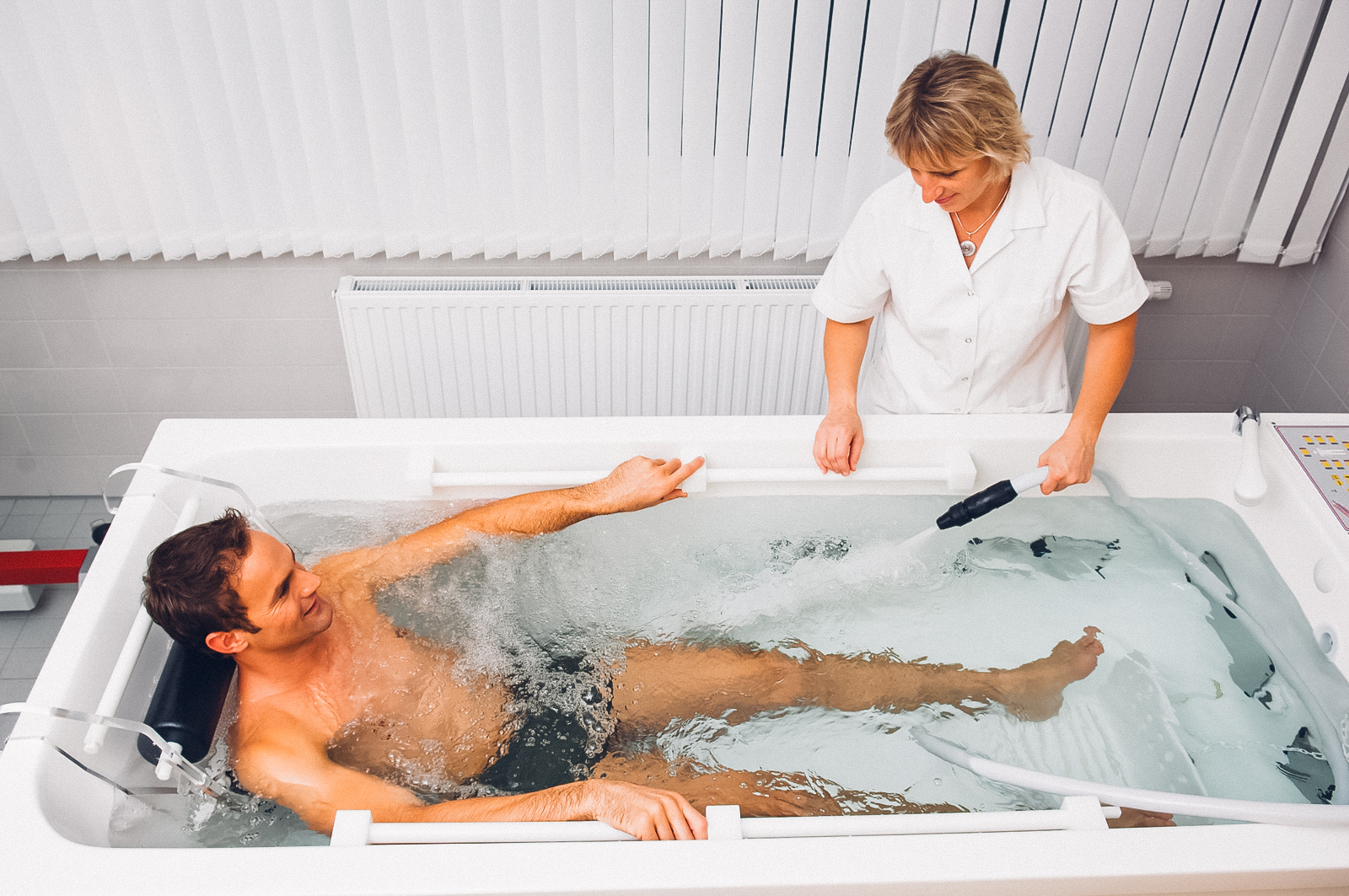 Hydrotherapie-Anwendung mit Wasserdruckstrahl in moderner medizinischer Badewanne.