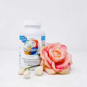 man sieht eine Packung LQ-Kapseln und eine rosarote Blume