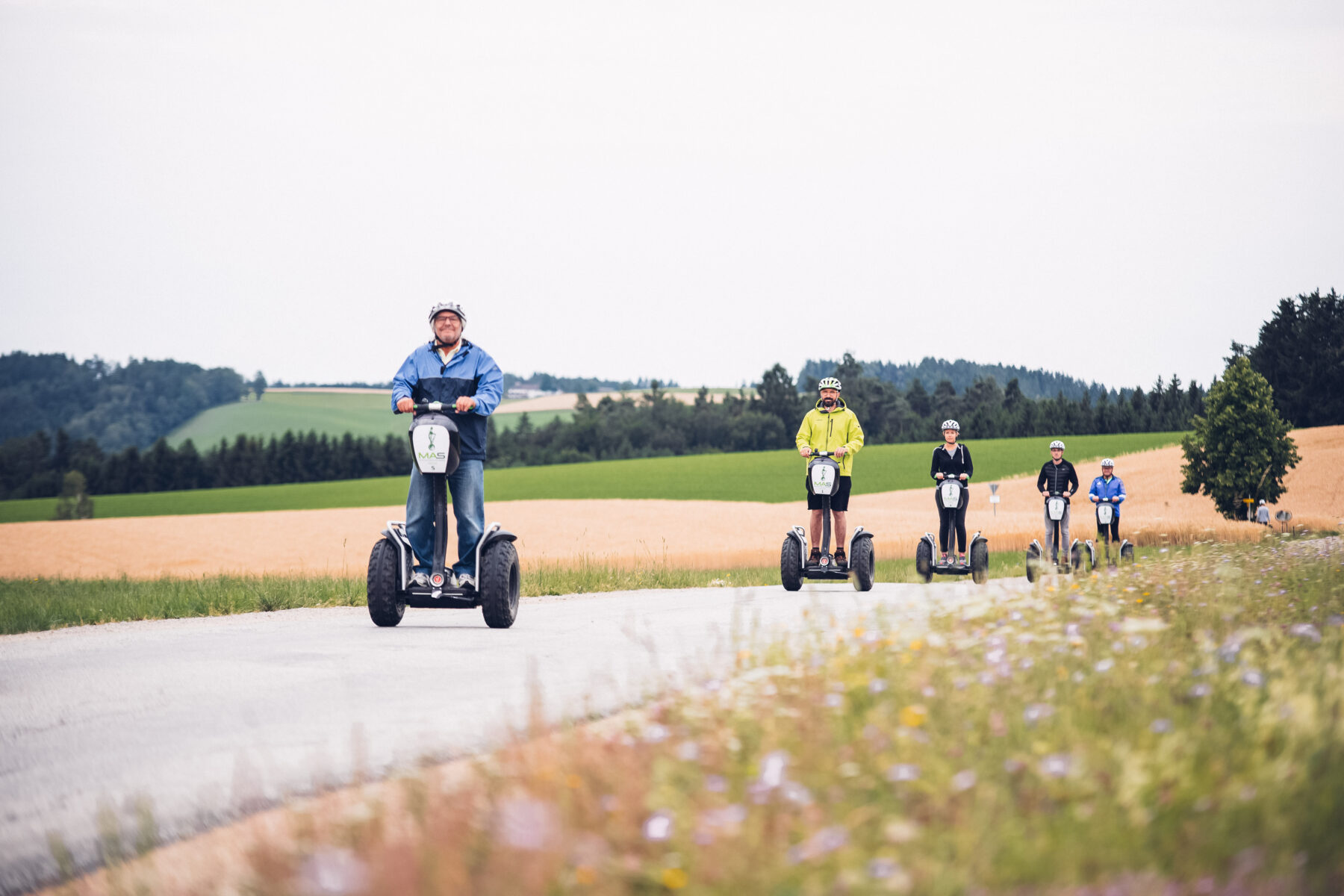 Eine Gruppe fährt im Mühlviertel hintereinander auf einer Straße mit Segways.