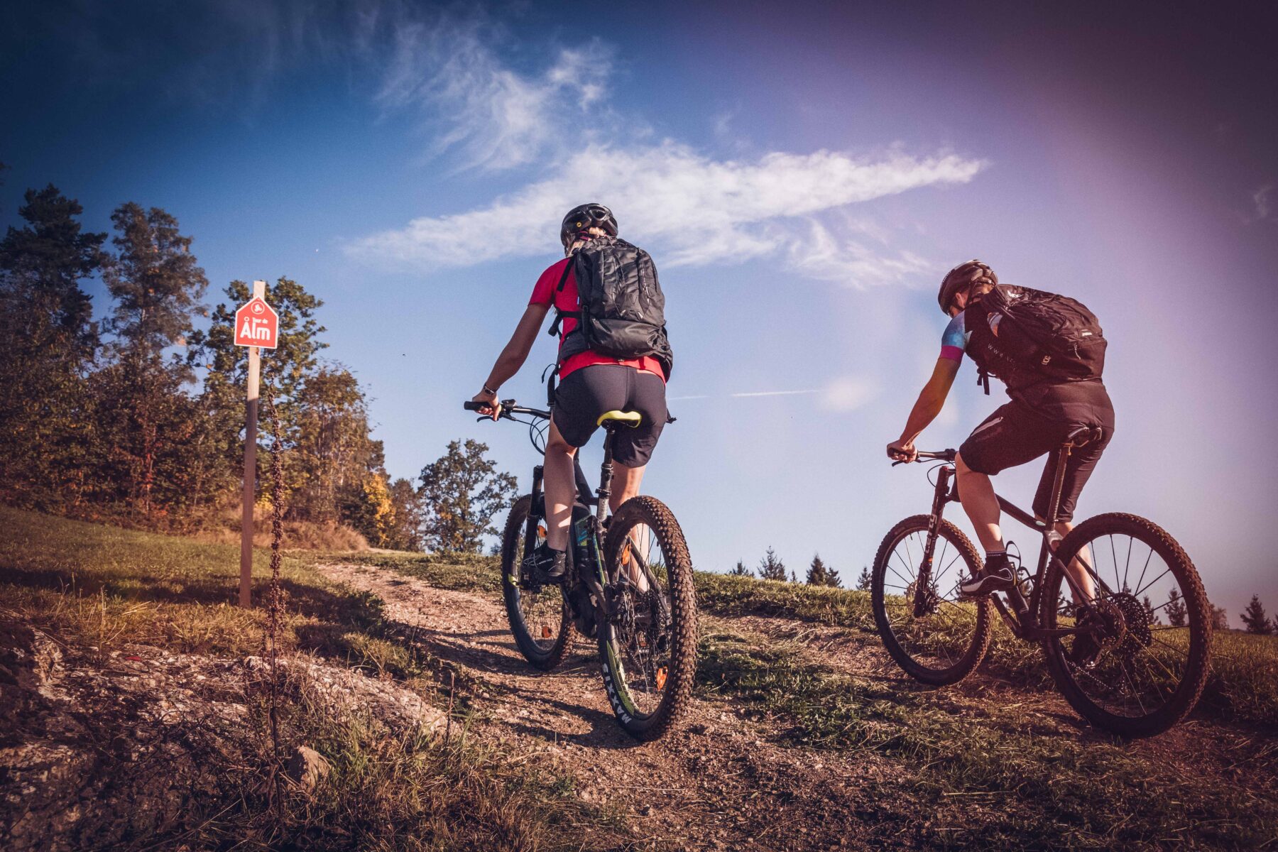 Man sieht zwei Radfahrer am weg "Tour de Alm".
