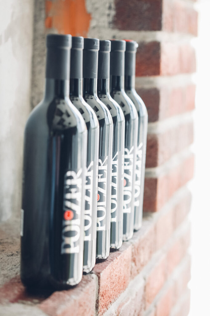 Man sieht hintereinandergestellte Weinflaschen von der Seite.