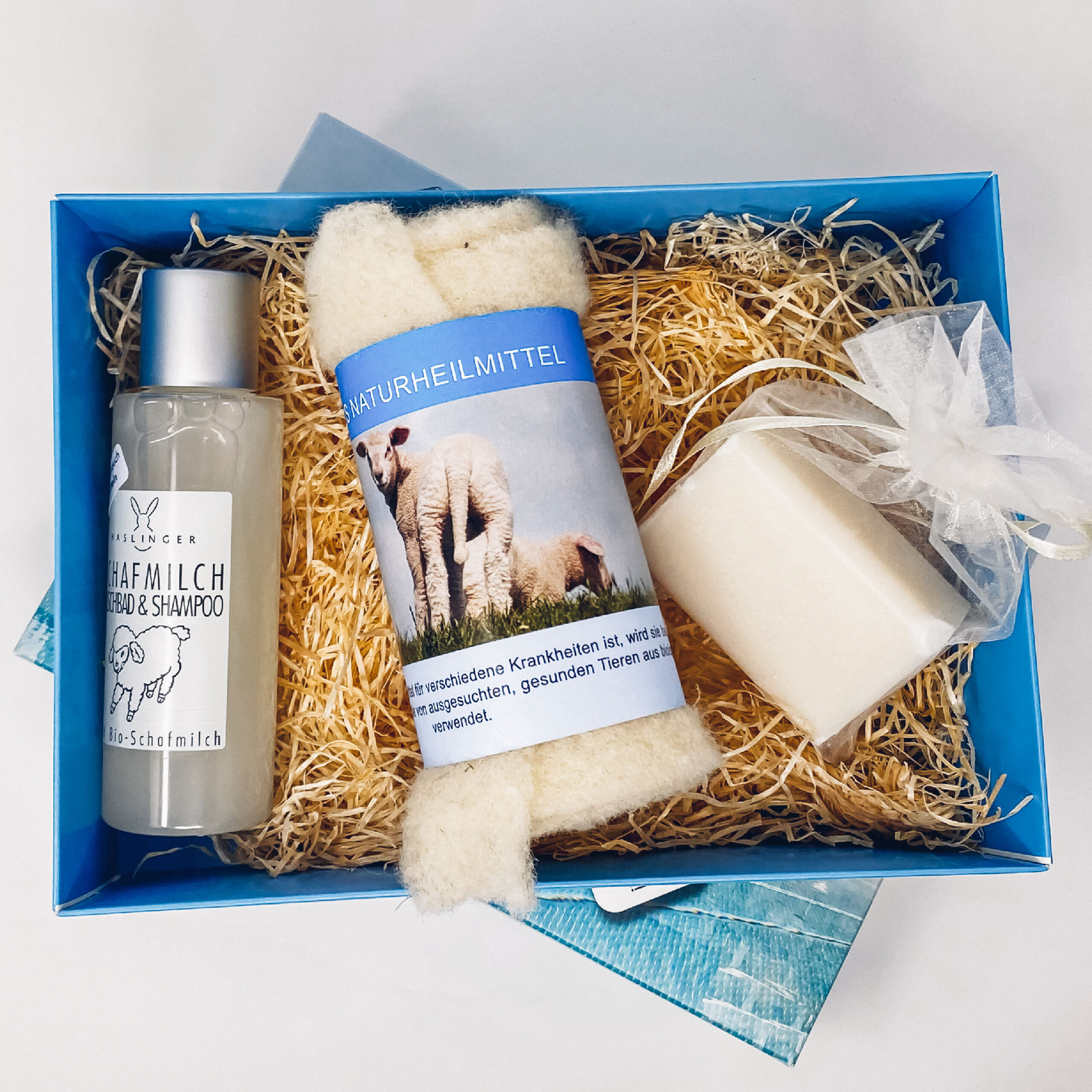 Geschenkbox gefüllt mit Schafmilch-Shampoo, Schafseife und einem Schafwickel