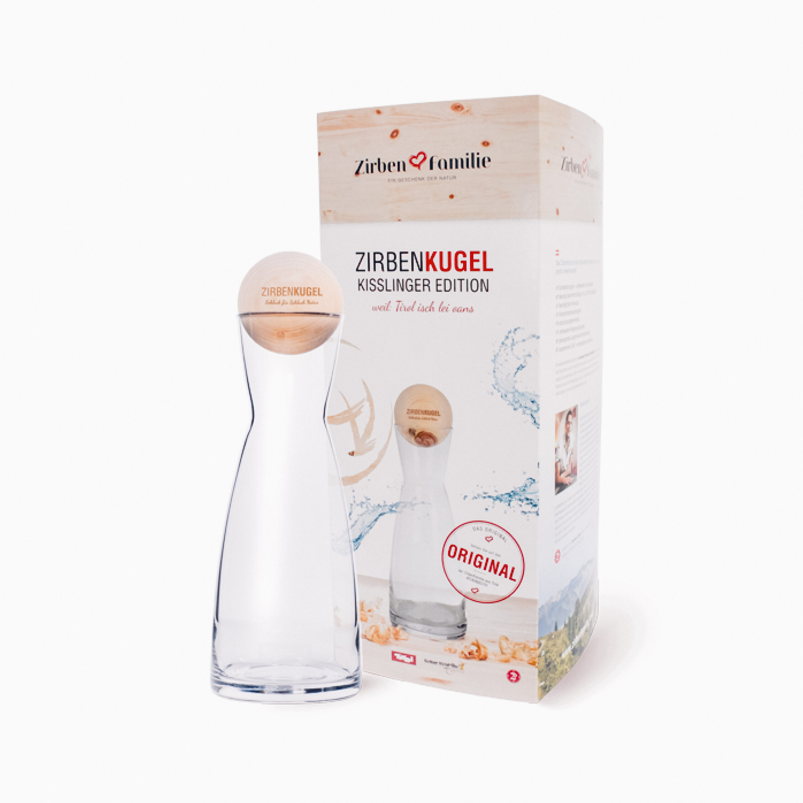 Man sieht die Verpackung und eine Wasserkarave mit einer Zirbenkugel als Deckel