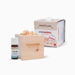 Man sieht einen Zirbenwürfel und ein Zirbenöl mit Verpackung